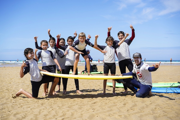 groupe d'enfants apprenant à faire du surf avec l'école Soonline