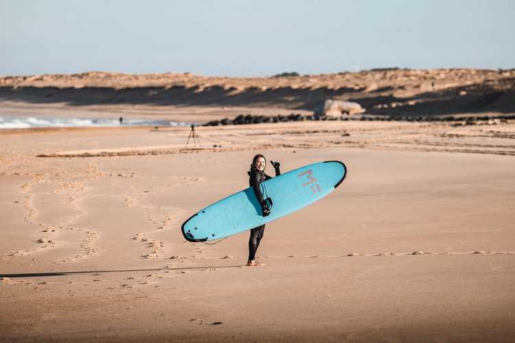 Une surfeuse sur la plage leve le pouce